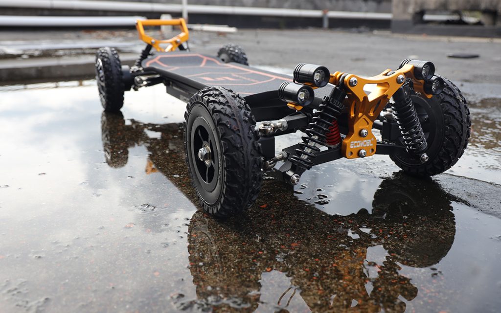 Ecomobl M24 2WD off-road electric skateboard with orange suspension and all-terrain tires