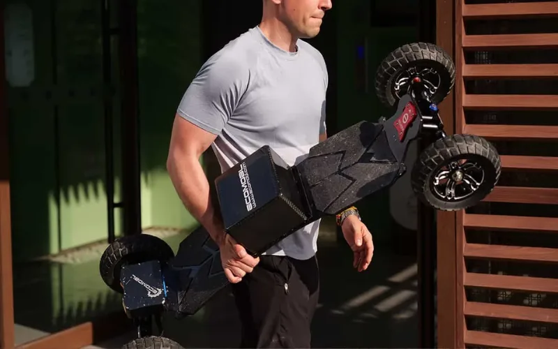 man carrying telum 2wd electric skateboard
