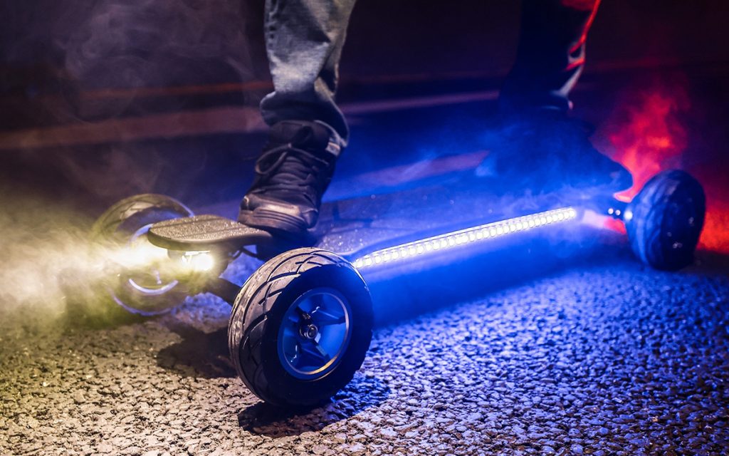 Ecomobl ET Pro 2WD electric skateboard with LED lights on asphalt at night. All-terrain e-board.