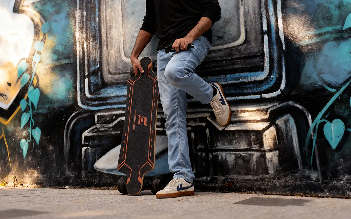 MAn standing with Street Electric Skateboard