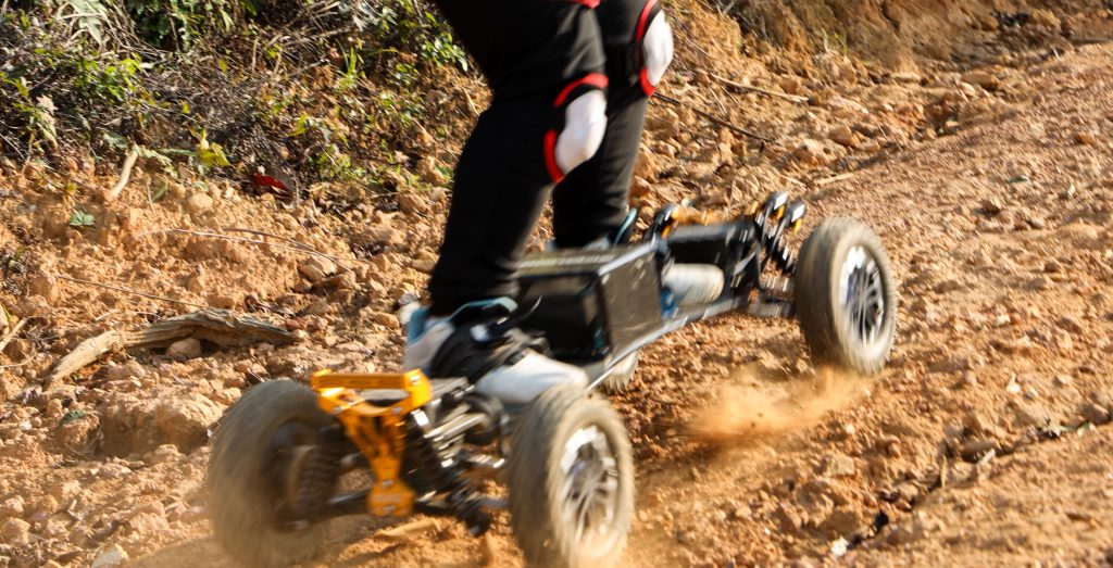 Person riding an electric skateboard on a dirt trail