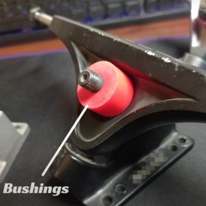 Close-up of a skateboard bushing, highlighting the red bushing on the truck.