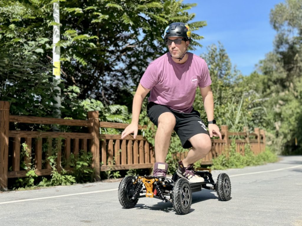 Person riding an electric skateboard on a sunny path.
